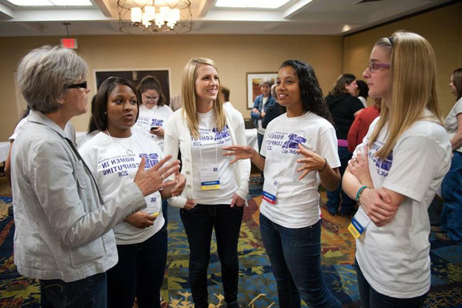 Dr. Carol Spradling, right, converses with women at the biannual Missouri Iowa Nebraska Kansas Women in Computing Conference, which she co-founded.